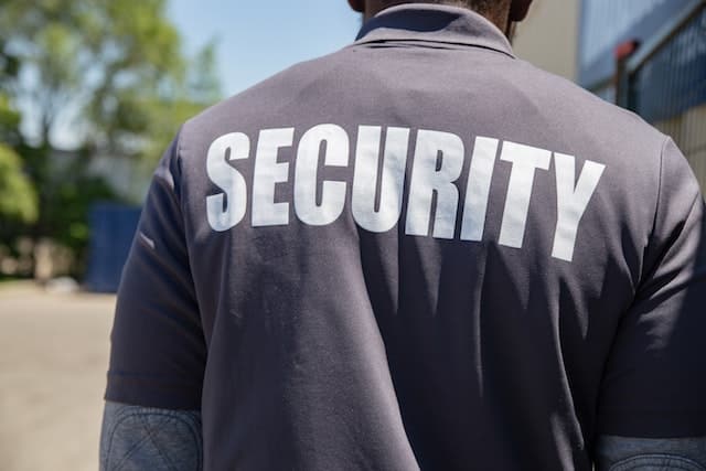 The back of a security guard wearing a security shirt